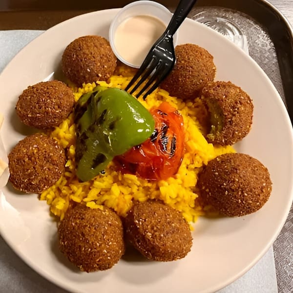 Cedar Grill's falafel plate with yellow rice, grilled peppers, and a side of sauce.