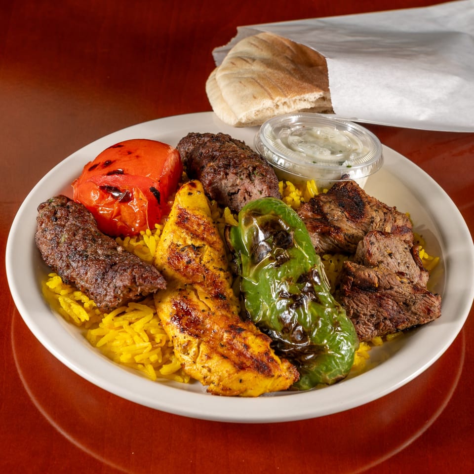 Cedar Grill's Mediterranean platter with grilled meats, yellow rice, roasted vegetables, and pita bread.